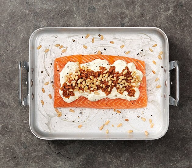 Lax i ugn med pesto, crème fraîche och pinjenötter